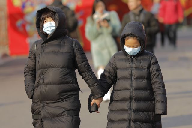 Védőmaszkos gyalogosok Pekingben 2020. január 21-én. A kínai fővárosban és a dél-kínai Sencsenben is felbukkant új, tüdőgyulladást okozó vírus kiindulópontjának számító közép-kínai Vuhanban jelentősen megugrott a fertőzöttek száma, a vírusfertőzés eddig legkevesebb négy ember halálát okozta. (Fotó: MTI/EPA/Vu Hong )