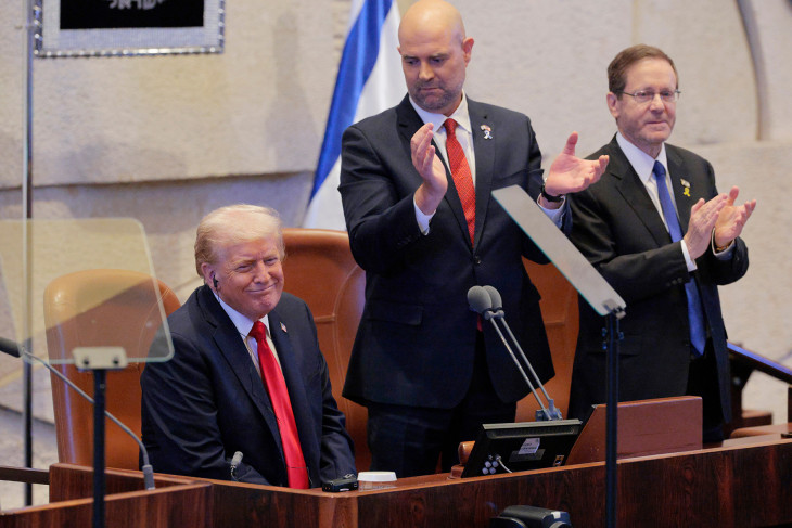 Szerényen learatja a babérokat? Donald Trump Amir Ohana házelnök (középen) és Jichak Hercog izraeli elnök (jobbra) társaságában az izraeli parlament jeruzsálemi üléstermében a tiszteletére tartott rendkívüli ülésen 2025. október 13-án