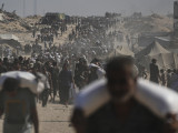  Humanitárius segélyként kapott liszteszsákot visznek palesztin emberek a Gázai övezet északi részén fekvő Bét-Lahíjában 2025. augusztus 23-án. 