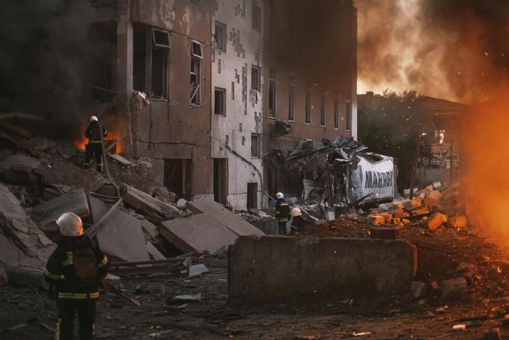 Lángoló épületnél tűzoltók a dél-ukrajnai Mikolajivban egy orosz tüzérségi támadás után, 2022. június 18-án. MTI/AP/George Ivanchenko