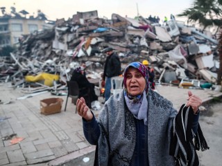 Minden romokban - emberek egy összedőlt épület előtt a súlyos földrengés után a törökországi Hatayban, 2023. február 08-án. Az áldozatok száma szerda délelőtt már megközelíti a tízezret, rengeteg a sérült a február 6-i két súlyos földrengés után. Fotó: EPA / Erdem Sahin
