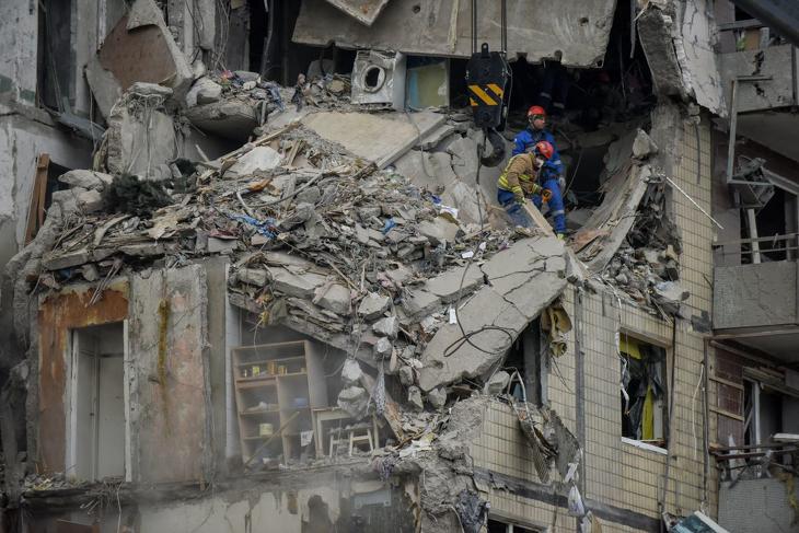 Romeltakarítást végző mentők 2023. január 15-én, miután az előző nap orosz rakétatalálat ért egy lakóházat az ukrajnai Dnyipróban. Ez a támadás legalább 25 ember életébe került. Fotó: MTI/EPA