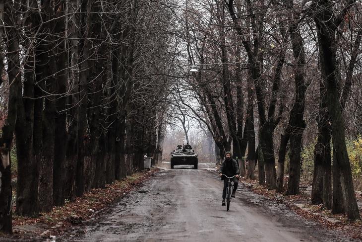 Egy harckocsi és egy bicikli egy úton Donbászban 2023. november 9-én. Fotó: EPA/OLEG PETRASYUK