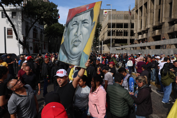 Kormánypárti tüntetők Hugo Chávez korábbi venezuelai elnök képével a caracasi elnöki rezidencia, a Miraflores palota közelében 2026. január 3-án