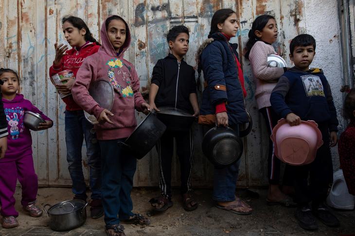  Menekült palesztin gyerekek állnak sorba élelemért a Gázai övezet déli részén fekvő Khan Juniszban 2024. január 9-én.