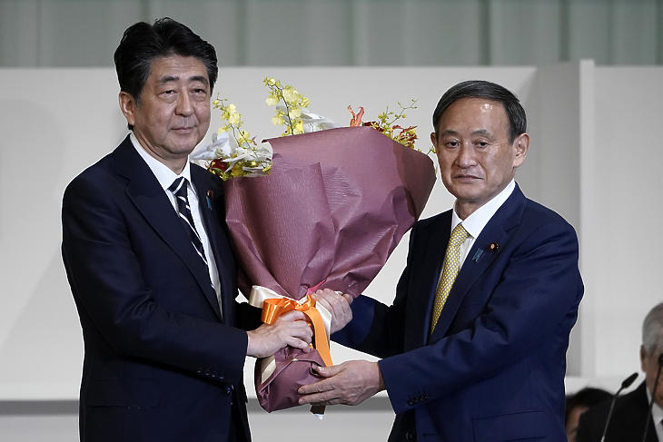 Abe Sindzó japán miniszterelnök (b) virágot nyújt át Szuga Josihide kormányszóvivőnek, miután utóbbi megnyerte a japán kormánypárt, a Liberális Demokrata Párt (LDP) új vezetőjének megválasztására kiírt szavazást Tokióban 2020. szeptember 14-én. (Fotó: MTI/AP pool/Eugene Hoshiko)