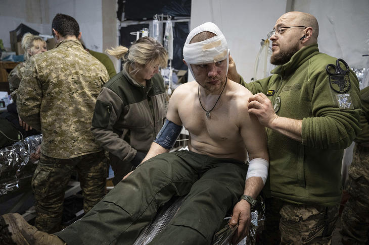 Sebesült ukrán katonát lát el egy szanitéc egy tábori kórházban az ukrajnai háború frontvonalánál, a Donyeck megyei Bahmut térségében 2023. február 26-án. Fotó: MTI/AP/Jevhen Maloletka 