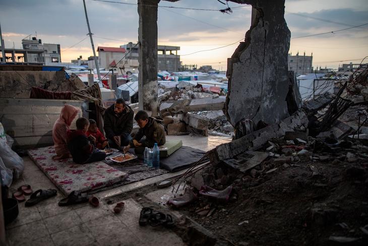 Gázai család egy lerombolt épületben Rafahban