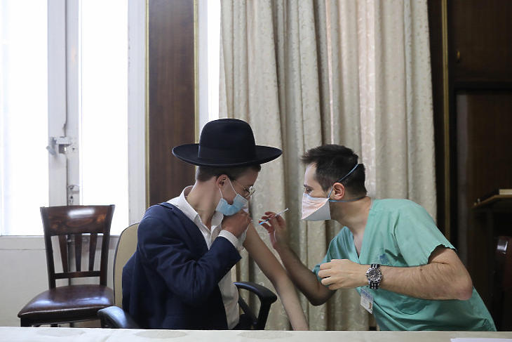 Ultraortodox zsidó fiú megkapja a koronavírus elleni vakcinát az Ichilov Egészségügyi Központban a Tel-Avivtól keletre fekvő Bnei Brakban 2021. február 11-én. Illusztráció. (Fotó: MTI/EPA/Abir Szultan)