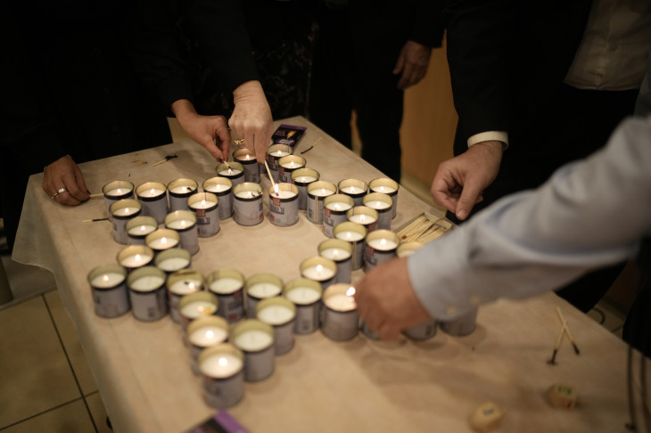 Gyászolók égő mécsesekből rakják ki a Dávid csillagot az ausztráliai Sydney város Bondi Beach nevű tengerparti strandján elkövetett terrortámadás áldozataira emlékezve Jeruzsálemben 