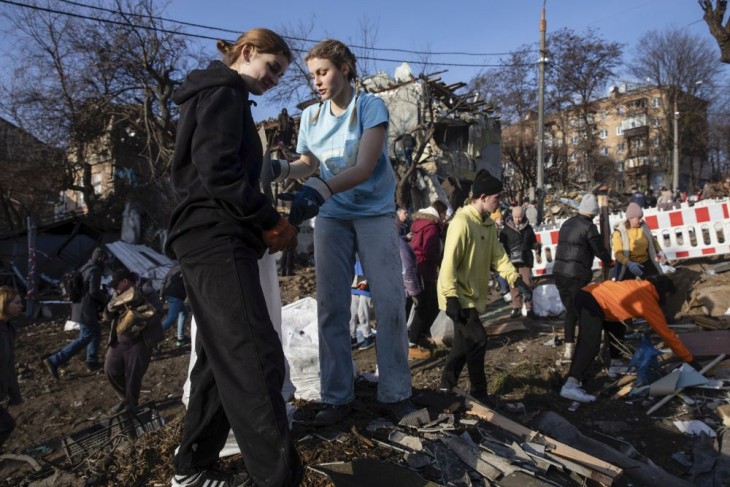 Önkéntesek takarítják a december 31-i orosz támadásban megsemmisült házak romjait Kijevben 2023. január 3-án. Fotó: MTI/EPA/Mihail Palincsak