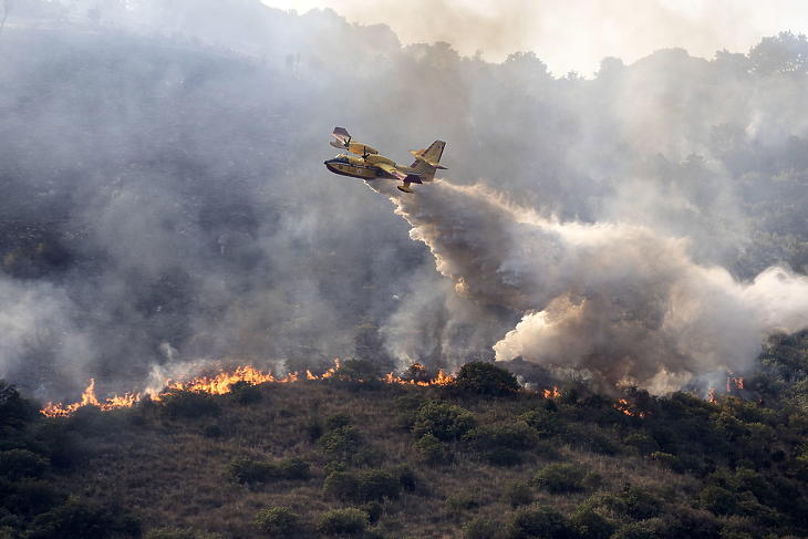 Repülőgépről ledobott tűzgátló anyaggal próbálják megfékezni a lángokat a Tivoli környékén pusztító erdőtűz helyszínén 2021. augusztus 12-én. (Fotó: MTI/EPA/ANSA/Massimo Percossi)