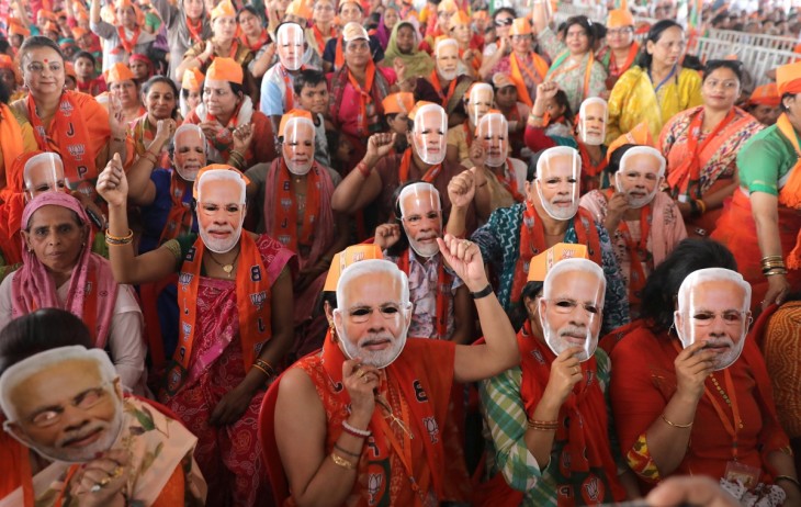 Narendra Modi indiai miniszterelnököt ábrázoló maszkot tartanak arcuk elé az országot kormányzó hindu nacionalista Bharatíja Dzsanata Párt (BJP) támogatói pártjuk első kampánygyűlésén az Uttar Prades állambeli Mirátban 2024. március 31-én