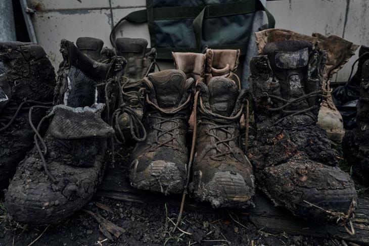 Sebesült ukrán katonák bakancsai a kelet-ukrajnai Donyecki területen, a bahmuti front közelében lévő tábori kórházban. Fotó: MTI/AP