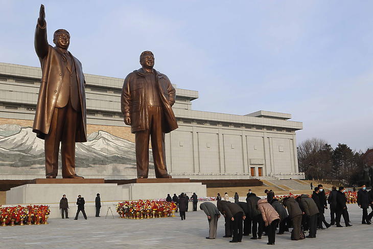 A kommunista Észak-Koreát megalapító Kim Ir Szen (b) és fia, Kim Dzsong Il néhai észak-koreai vezetők bronzszobra előtt róják le kegyeletüket az emberek Kim Dzsong Il születésének 79. évfordulója alkalmából a phenjani Manszu-dombon 2021. február 16-án. (Fotó: MTI/AP/Dzson Csol Dzsin)