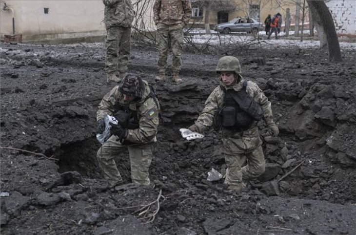 Orosz rakétatámadásban keletkezett bombatölcsérből szed össze rakétamaradványokat két ukrán katona a kelet-ukrajnai Kramatorszkban 2023. február 2-án. A támadás következtében legalább két ember életét vesztette, hét pedig megsebesült. Fotó: MTI/EPA/Szerhij Seszták