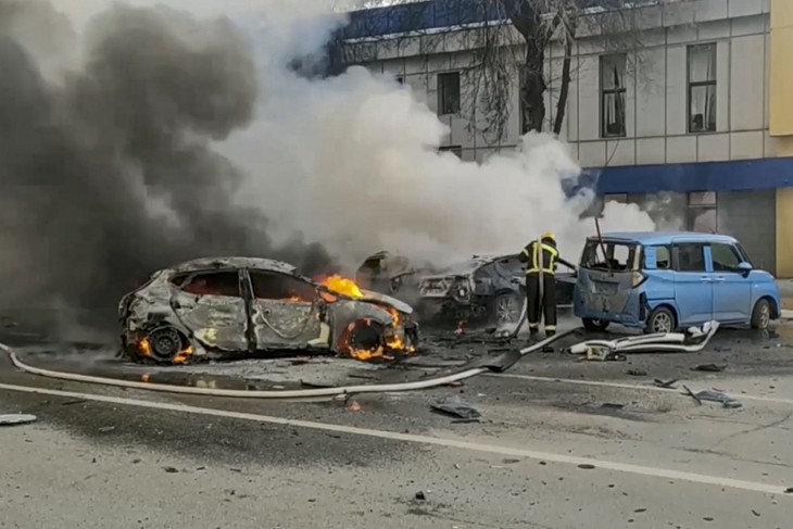 Tűz van, roncsok vannak, becsapódási kráter azonban itt sincs: lángoló autókat locsol egy orosz tűzoltó Belgorod orosz terület azonos nevű székhelyén 2023. december 30-án.  Fotó: MTI/EPA/Rendkívüli helyzetek orosz minisztériuma 