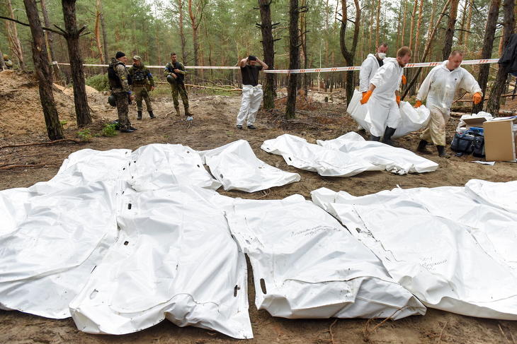 Hullazsákot visznek az azonosítatlan áldozatok földi maradványait exhumáló csoport tagjai a kelet-ukrajnai Harkiv megyében levő Izjumnál 2022. szeptember 16-án, a tömegsír felfedezésének másnapján. Fotó: MTI/EPA/Oleg Petraszjuk
