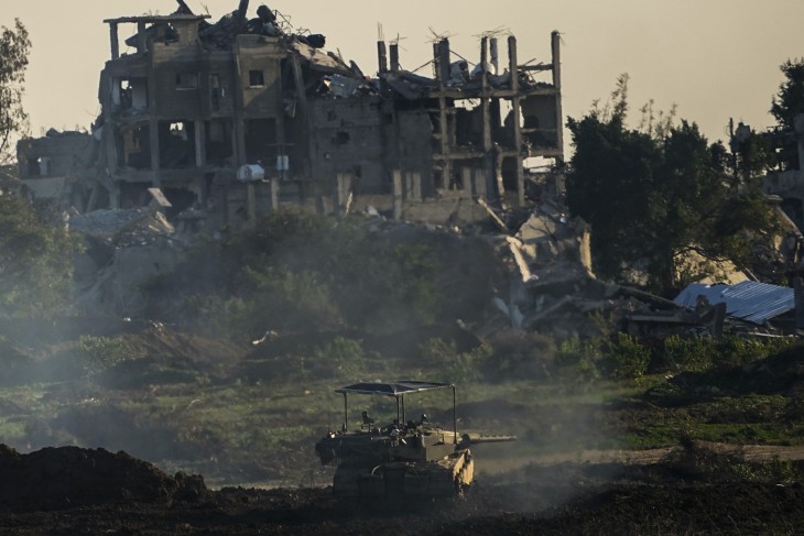 Izraeli harckocsi egy romos épület előtt, a Gázai övezet északi részén 2023. december 17-én. Fotó: MTI/AP/Ariel Schalit