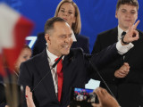 A lengyel ellenzéki Jog és Igazságosság (PiS) párt támogatásával induló elnökjelölt, Karol Nawrocki történész, a lengyel Nemzeti Emlékezet Intézete elnöke köszönti támogatóit az elnökválasztás második fordulóját követő eredményvárón Varsóban 2025. június elsején.