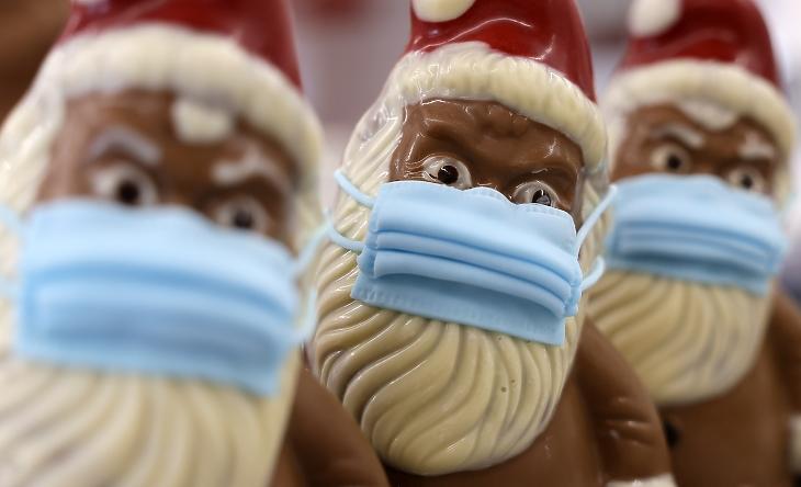 Védőmaszkos csokimikulások sorakoznak egy polcon a Wawi német csokoládégyártó cég Pirmasens városban lévő üzemében 2020. november 27-én, a koronavírus-járvány idején. MTI/EPA/Ronald Wittek