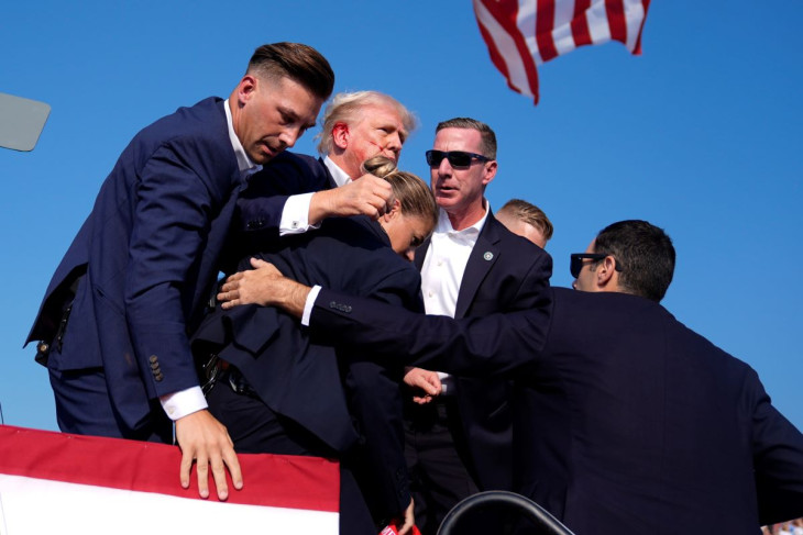 Donald Trump volt amerikai elnököt, a Republikánus Párt elnökjelöltjét a védelmét ellátó titkosszolgálat ügynökei veszik körbe a Pennsylvania állambeli Butlerben rendezett kampánygyűlésen 2024. július 13-án. A rendezvényen Trump beszéde közben lövések dördültek, a politikus a jobb fülén megsérült, de védőgyűrűben a saját lábán hagyta el a pódiumot. Az elnökválasztást november 5-én tartják az Egyesült Államokban
