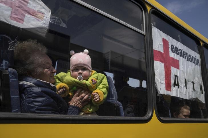 Az orosz támadások miatt Szeverszkből kimenekített nő és gyerek a kelet-ukrajnai Lyman közelében. A busz ablakán felirat: Gyerekek. Fotó: MTI/AP/Jevhen Maloletka