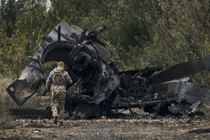  Orosz harckocsi roncsa mellett ukrán katona az ukrán hadsereg által frissen visszafoglalt területen, a Harkivi területen fekvő Balaklejába vezető úton 2022. szeptember 11-én. Fotó: MTI/AP 