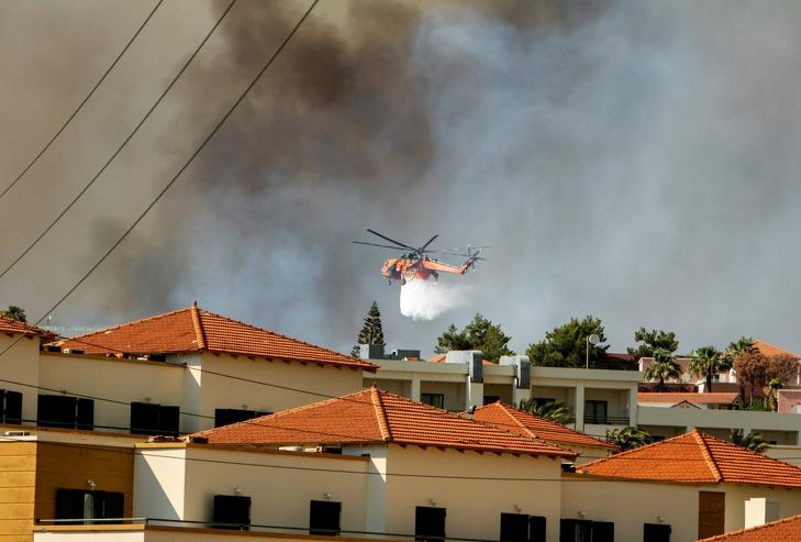 Vizet hord a lángoló növényzetre az oltásban részt vevő légi járművek egyike a Rodosz szigetén fekvő Kiotari falu határában 2023. július 22-én. A hőség és tartós csapadékhiány miatt Athén térségében is erdőtüzek pusztítanak. Fotó: MTI/EPA/ANA-MPA/Damianidisz Lefterisz 