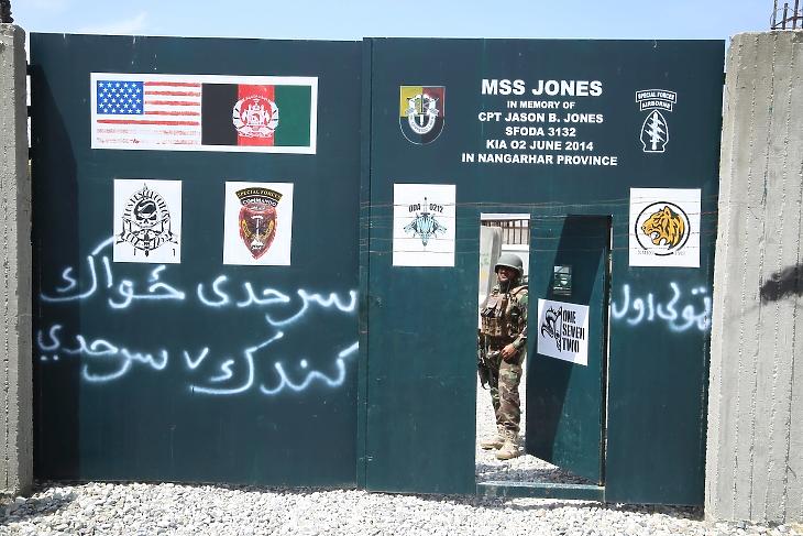 Afgán katona őrködik egy katonai bázison 2021. április 14-én, amelyet korábban az amerikai hadsereg használt. A felirat alapján egy olyan amerikai katonáról nevezték el a bázist, aki 2014 júniusában ütközetben esett el Afganisztánban. Fotó: EPA/Ghulamullah Habibi