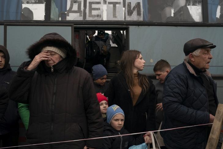 Mariupolból és a környező városokból érkező buszból szállnak ki az orosz támadások elöl menekülő emberek egy zaporozzsjai fogadóközpontnál. A busz ablakában orosz nyelvű felirat: Gyerekek. Fotó: MTI/AP/Leo Correa