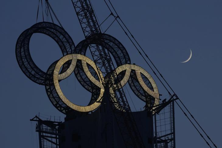Munkások szerelik össze az olimpiai ötkarikát egy pekingi torony tetején 2022. január 5-én. Peking február 4-20. között rendezi a 2022-es téli ötkarikás játékokat. Fotó: MTI/AP