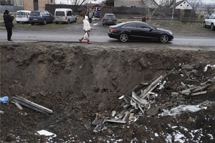 Orosz rakéta becsapódása nyomán keletkezett kráter mellett halad el egy autó a Kijev megyei Hlevakha településen 2023. január 26-án. Fotó: MTI/AP/Roman Hricina