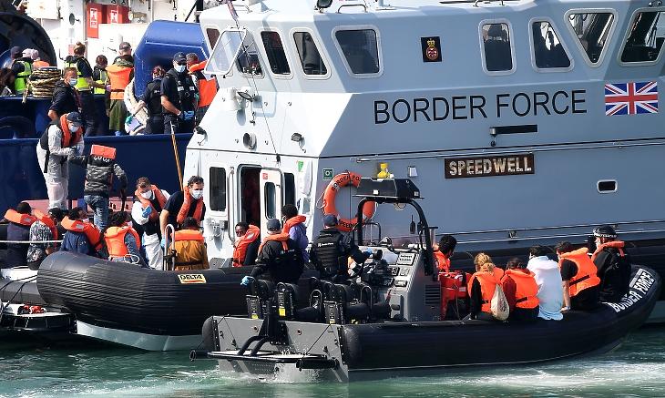 Menekültek szállnak át a brit határőrség hajójára Dovernél. Fotó: EPA / Andy Rain.