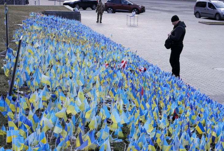 Az elesett ukrán katonák emlékére elhelyezett zászlókat nézi egy férfi a kijevi Függetlenség terén 2023. február 22-én. Fotó: MTI/EPA/Szerhij Dolzsenko