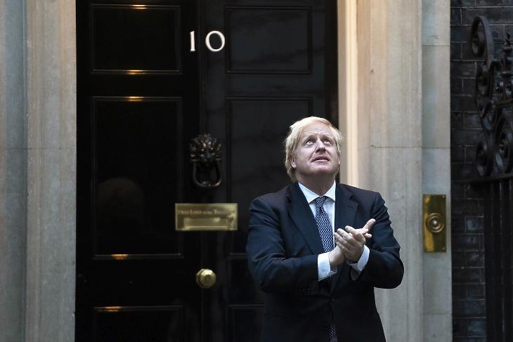 A koronavírus okozta betegségből felgyógyult Boris Johnson brit miniszterelnök a londoni kormányfői rezidencia, a Downing Street 10. kapujában 2020. április 30-án részt vesz a tapsoljunk a rólunk gondoskodóknak mottóval meghirdetett hetenkénti akcióban, amikor az emberek Nagy-Britannia-szerte tapssal köszönik meg mindazok tevékenységét, akik a koronavírus-járvány alatt a lakosság biztonságáért, egészségéért, ellátásáért, az ország működőképességének fenntartásáért dolgoznak. MTI/EPA/Will Oliver