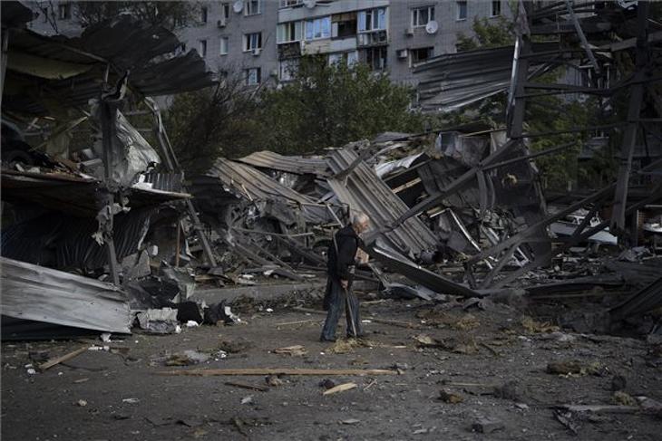Romba dőlt autószalon mellett egy öreg férfi a délkelet-ukrajnai Zaporizzsjában egy orosz rakétatámadás után, 2022. október 11-én. Ukrán források szerint egy ember életét vesztette. Fotó: MTI/AP/Leo Correa