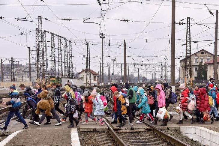 A dél-ukrajnai Hulaipole településen működő árvaházból kimenekített gyerekek mennek csomagjaikkal Lviv vasúti pályaudvarán 2022. március 7-én. Fotó: MTI/PAP