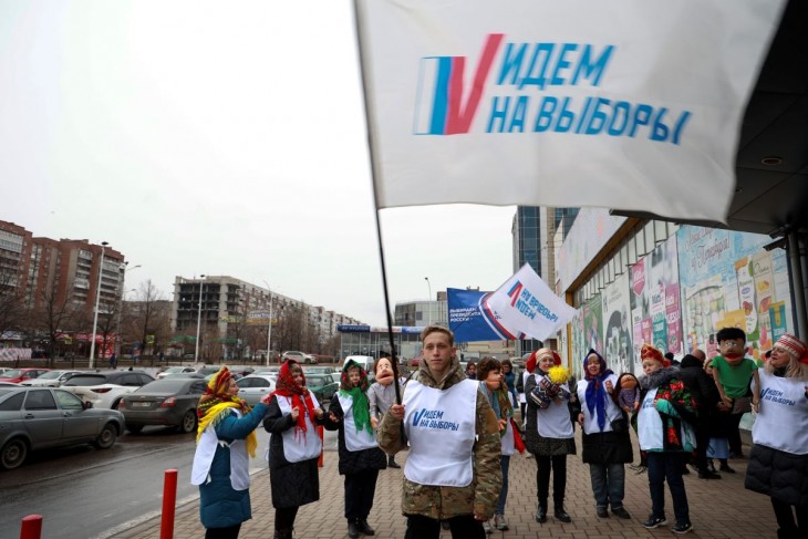 Választási részvételre buzdít egy csoport önkéntes az Oroszországhoz csatolt kelet-ukrajnai Donyeckben 2024. március 14-én. A zászló feliratának jelentése: menjünk el a választásra. Az elnökválasztást március 15-17-én tartják Oroszországban. Fotó: MTI/AP