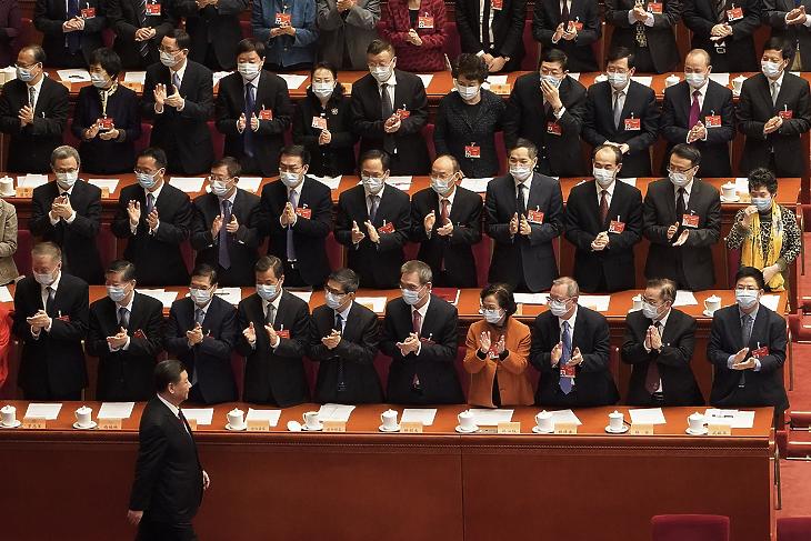 A koronavírus-járvány miatt védőmaszkot viselő küldöttek tapsolnak, amint Hszi Csin-ping kínai elnök, a Kínai Kommunista Párt főtitkára a Kínai Népi Politikai Tanácskozó Testület (KNPTT) záróülésére érkezik a pekingi Nagy Népi Csarnokban 2021. március 10-én. (Fotó: MTI/AP/Mark Schiefelbein)