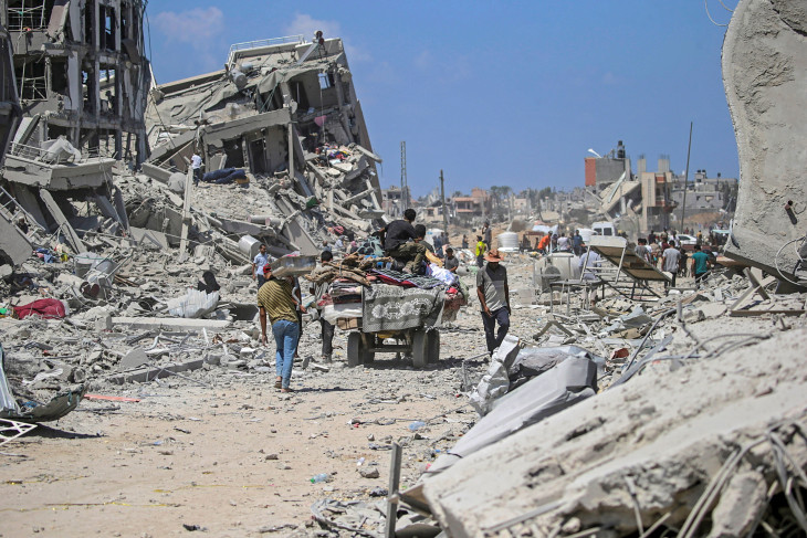 . Palesztin emberek öszvér vontatta kordéval térnek vissza otthonuk romjaihoz az izraeli csapatok újabb szárazföldi művelete után a Gázai övezet középső részén levő Deir al-Balah városban 2024. augusztus 29-én. 