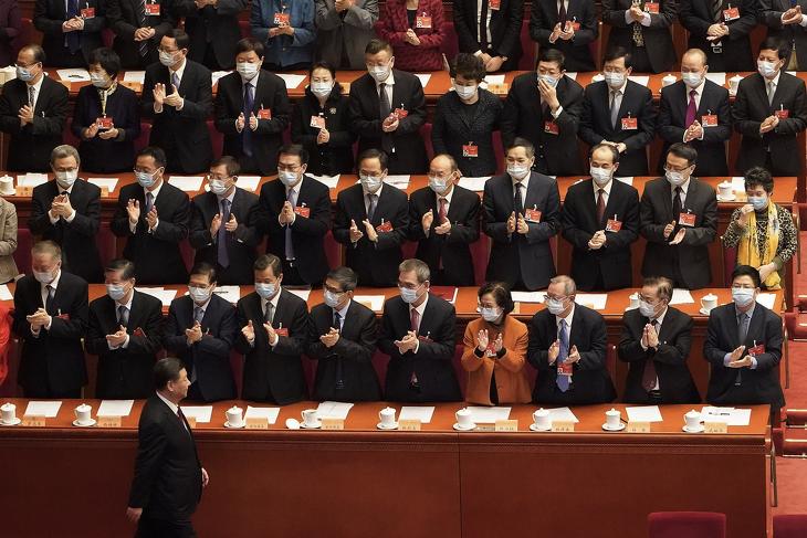 A koronavírus-járvány miatt védőmaszkot viselő küldöttek tapsolnak, amint Hszi Csin-ping kínai elnök, a Kínai Kommunista Párt főtitkára a Kínai Népi Politikai Tanácskozó Testület (KNPTT) záróülésére érkezik a pekingi Nagy Népi Csarnokban 2021. március 10-én. Fotó: MTI/AP/Mark Schiefelbein