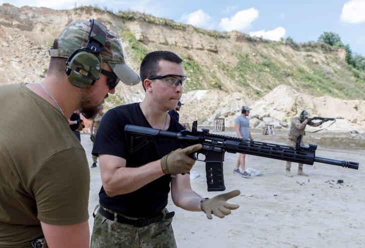 Ukrán polgári lakosokat tanítanak lőfegyverrel bánni egy lembergi lőtéren 2022. július 30-án, az Ukrajna elleni orosz háború alatt. MTI/EPA