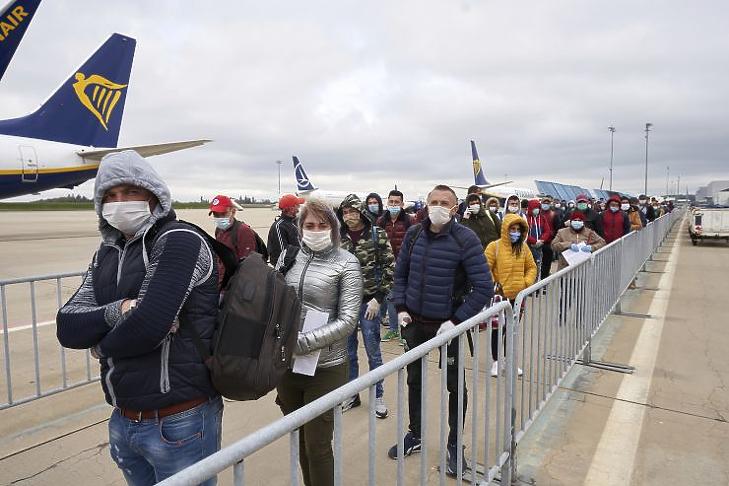 Védőmaszkot viselő román mezőgazdasági idénymunkások érkeznek a németországi Hahn repülőterére (Fotó: MTI/AP/DPA/Thomas Frey)