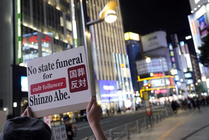 Egy aktivista tiltakozik Shinzo Abe volt japán miniszterelnök közelgő állami temetése ellen Tokióban, Japánban, 2022. szeptember 21-én. Korábban a nap folyamán egy férfi felgyújtotta magát Abe állami temetése ellen tiltakozva. A japánok több mint 50 százaléka ellenzte a meggyilkolt politikus állami temetését, miután a merényletet követően szoros kapcsolatokról számoltak be Abe és az Egyesítő Egyház között. EPA / Franck Robichon