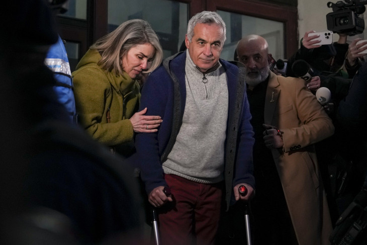 Calin Georgescut, a romániai elnökválasztás november 24-i első fordulójában legtöbb szavazatot szerző független jelöltet a felesége, Cristela kíséri, amint távozik a legfőbb ügyészség bukaresti épületéből 2025. február 26-án. 