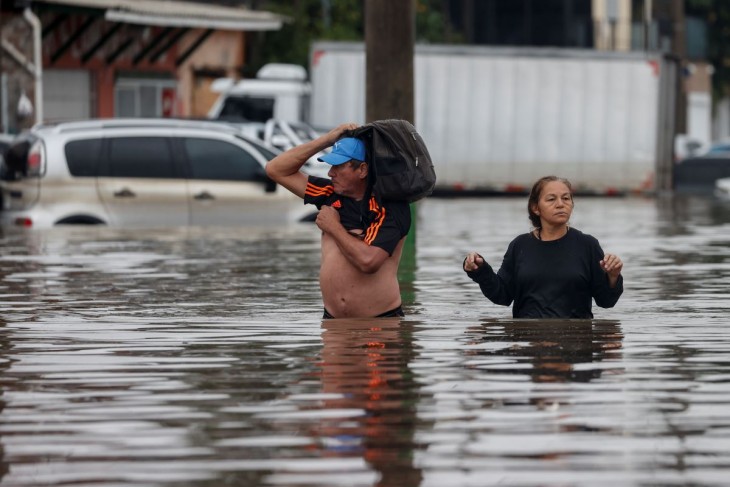 Árvízben gázolnak emberek a Brazília déli részén elterülő Rio Grande do Sul állam székvárosában, Porto Alegrében 2024. május 12-én. A természeti csapás következtében több, mint száz ember életét vesztette Brazília déli részén
