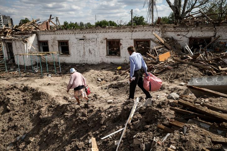 Emberek egy lerombolt iskolánál a frontvonalnál fekvő Orikhiv városban a Zaporizzsjai területen 2023. szeptember 7-én. Fotó: EPA/KATERYNA KLOCHKO