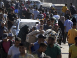  Dobozolt élelmiszeradományt fog egy palesztin fiú az amerikai központú Gázai Humanitárius Alapítvány, a GHF segélyszállítmányának elosztópontján a Gázai övezet déli határán fekvő Rafahban 2025. május 27-én.