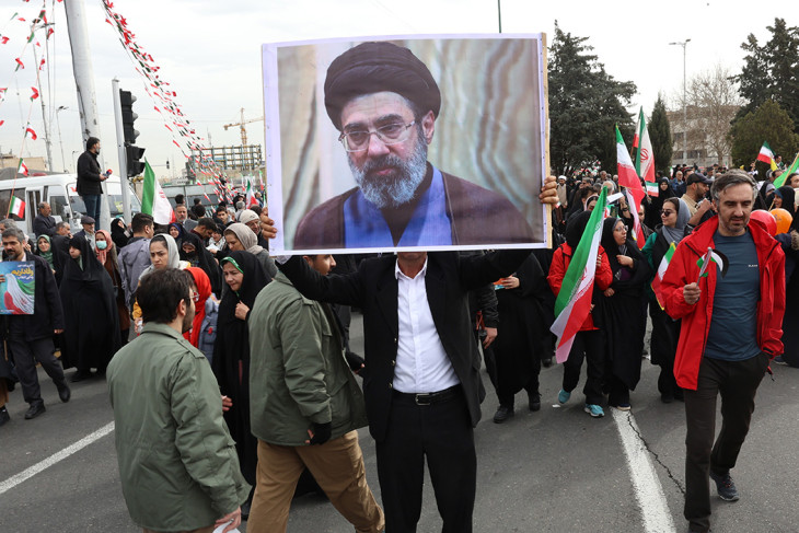 A 2026. február 11-i képen Modzstaba Hameneinek, Ali Hamenei ajatolláh, Irán legfőbb vallási és politikai vezetője fiának portréját fogja egy résztvevő az iráni iszlám forradalom győzelmének 47. évfordulója alkalmából tartott teheráni ünnepségen